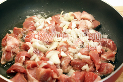 На разогретой сковороде с маслом обжарить кусочки мяса с мелко нашинкованным луком