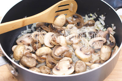 Мелко нашинкованную луковицу и ломтиками порезанные грибы обжаривать на растительном масле 5-7 минут