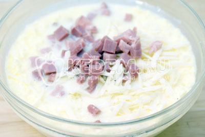 Добавить в миску к яично-молочной смеси ветчину с сыром, просеянную муку и разрыхлитель. Посолить.