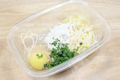 В миске смешать яйцо, тертый сыр и мелко нарубленную зелень. Добавить муку