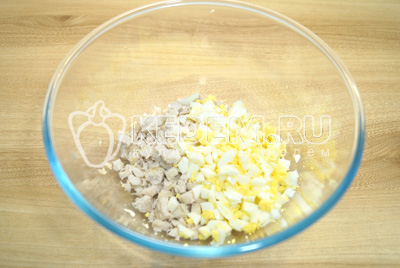 В миску нарезать мелким кубиками куриное филе и яйца.