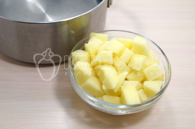 В кастрюле вскипятить 2-2,5 литра воды, добавить кубиками нарезанный картофель.