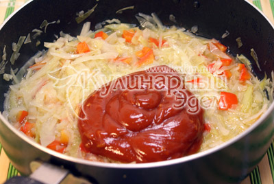 В сотейник с капустой и перцем добавить томатную пасту, посолить и перемешать, поставить на огонь