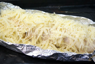Выложить на противень и запекать в духовке 30 минут при температуре 200 градусов С. Аккуратно снять с верху фольгу и посыпать оставшимся сыром