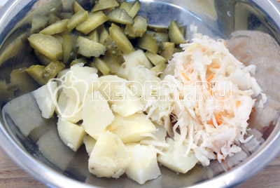 В миске смешать крупно нарезанный картофель, ломтиками нарезанные огурцы и капусту. Перемешать и заправить растительным маслом