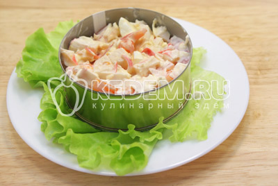 Заправить салат и выложить на блюдо с листьями салата в сервировочном кольце. 