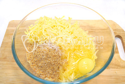 Добавить тертый сыр, панировочные сухарики, яйцо и соль.