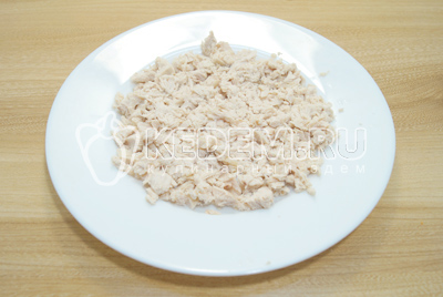 На плоское блюдо выложить мелко нарезанное куриное филе.
