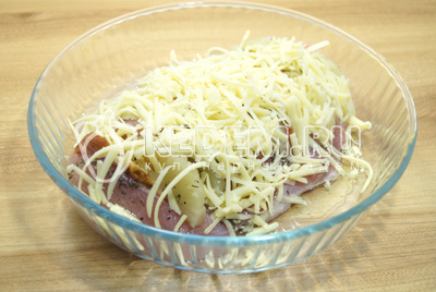 Выложить мясо в форму для запекания и хорошо посыпать тертым сыром.