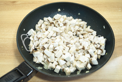 Добавить грибы в сковороду и готовить еще 5-7 минут. Посолить и поперчить по вкусу.