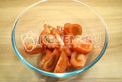 Крупными ломтиками нарезать помидоры в миску.
