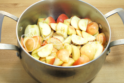 Сложить в кастрюлю и добавить четверть стакана воды, варить на среднем огне до мягкости яблок.