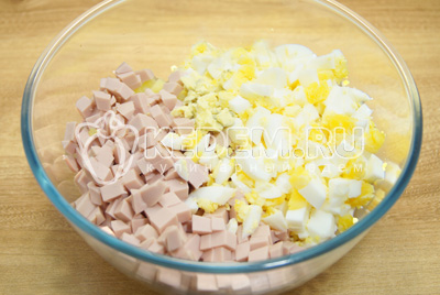 Нарезать кубиками в миску овощи. Добавить кубиками нарезанную вареную колбасу и яйца.