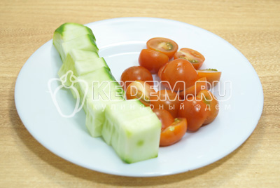 Огурцу придать квадратную форму(срезать кожуру) и нарезать кусочками, помидоры нарезать половинками.