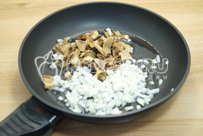 На сковороде с растительным маслом, обжарить мелко нашинкованный лук и нарезанные размоченные грибы.