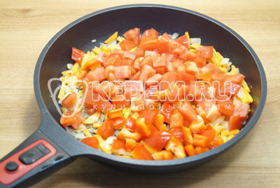 Добавить кубиками нарезанные помидоры и болгарский перец, готовить 2-3 минуты.