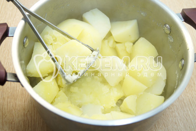 Слить воду с картофеля и хорошо размять толкушкой.