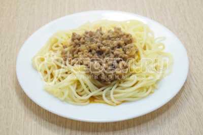 На тарелки выложить порцию спагетти и приправить подливой с фаршем.