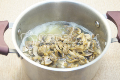 В кастрюлю с готовым картофелем добавить обжаренные грибы.