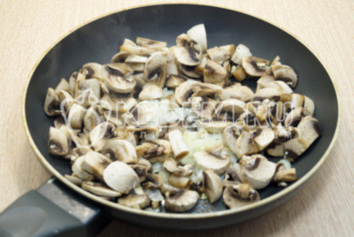 Лук мелко нашинковать, грибы нарезать и обжарить на сковороде с растительным маслом 3-5 минут, помешивая.