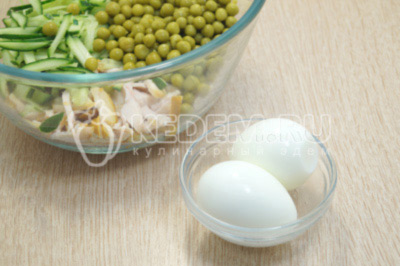 Добавить соломкой нарезанные огурцы и консервированный горошек. Яйца отварить и очистить.
