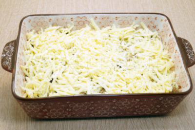 Посыпать половиной тертого сыра.