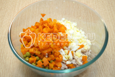 Добавить в миску кубиками нарезанные яйца и морковь.