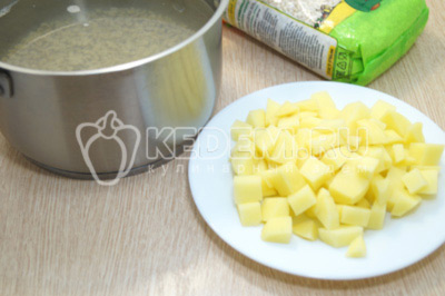 Добавить к крупе кубиками нарезанный картофель и варить еще 5-7 минут.