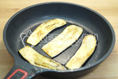 На разогретой сковороде с растительным маслом обжарить баклажаны по 2-3 минуты с каждой стороны.
