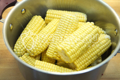 Если кукуруза слишком длинная, поломать на половинки каждый початок. Сложить в кастрюлю.