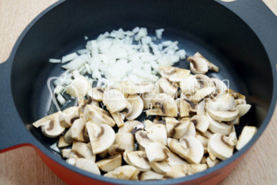 На сковороде с 2 столовыми ложками растительного масла обжарить нарезанные грибы и одну мелко нашинкованную луковицу.
