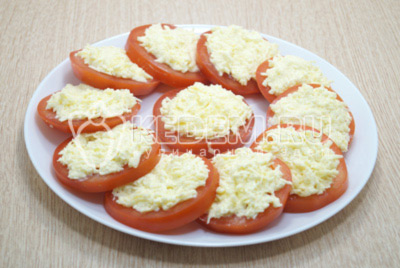 Выложить сырную начинку на колечки помидор.