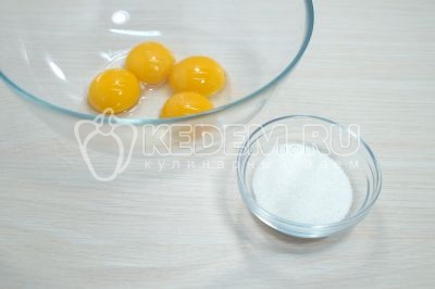 В миску с желтками добавить 2 столовые ложки сахара.