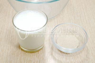 В миску влить 200 миллилитров теплого молока и добавить 1 чайную ложку сухих дрожжей.