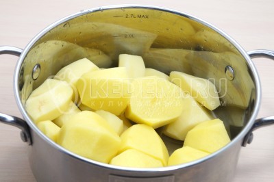 1 килограмм картофеля очистить, нарезать на четвертинки и сложить в кастрюлю.