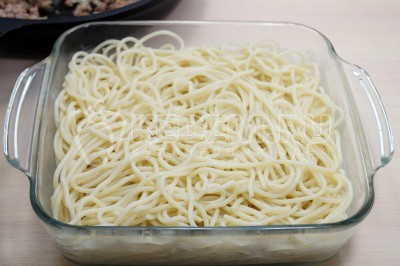 Выложить большую часть отварных спагетти.