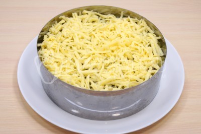 150 грамм твердого сыра натереть на средней терке. Выложить слой тертого сыра.