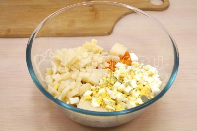 В большую миску нарезать кубиками картофель, морковь и яйца.
