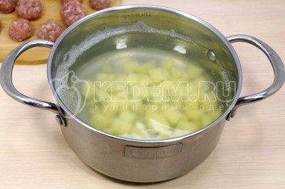 Картофель сложить в кастрюлю, влить 2,5 литра воды и довести до кипения.