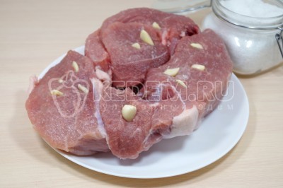 10 зубчиков чеснока нарезать на половинки и нашпиговать мясо со всех сторон.