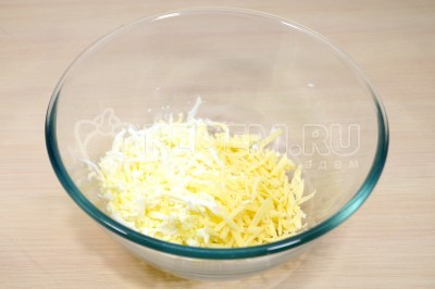 В миску натереть на терке отварные яйца и 100 грамм твердого сыра.